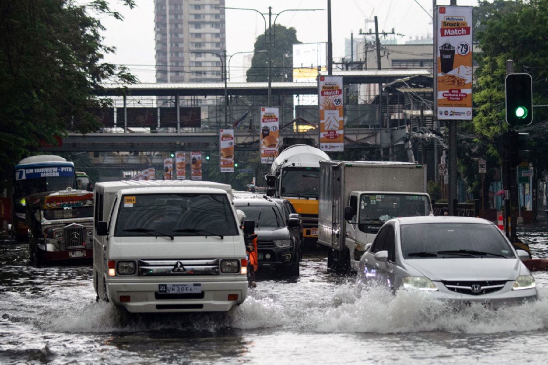 Vehículos transitan por calles inundadas en Manila, después de que el tifón Wipha provocara fuertes lluvias e inundaciones en Filipinas. Foto: AFP