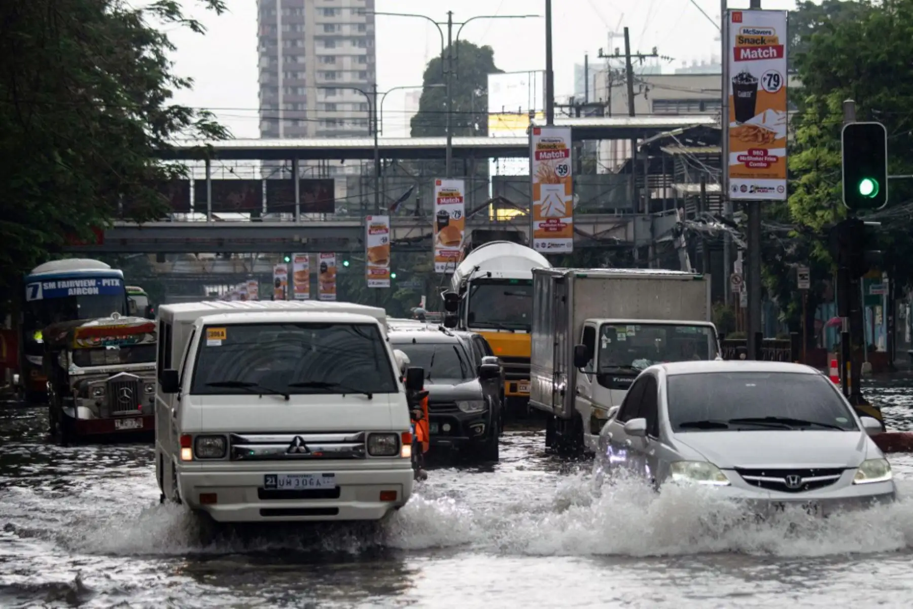 Vehículos transitan por calles inundadas en Manila, después de que el tifón Wipha provocara fuertes lluvias e inundaciones en Filipinas. Foto: AFP