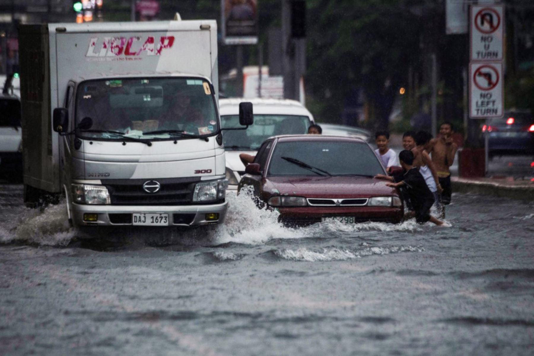 Vehículos transitan por calles inundadas en Manila, después de que el tifón Wipha provocara fuertes lluvias e inundaciones en Filipinas. Foto: AFP