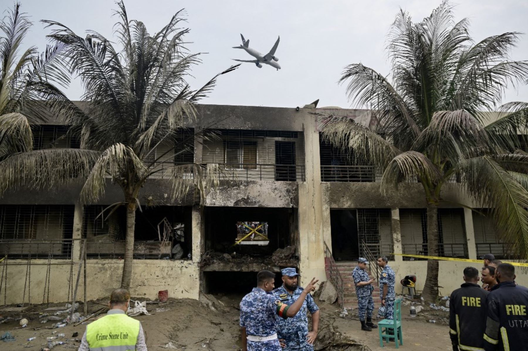 El personal de la Fuerza Aérea de Bangladesh inspecciona el lugar del accidente un día después de que un avión de entrenamiento se estrellara contra una escuela en Dacca el 22 de julio de 2025. Un avión de combate bangladesí se estrelló contra una escuela en la capital, Dacca. AFP