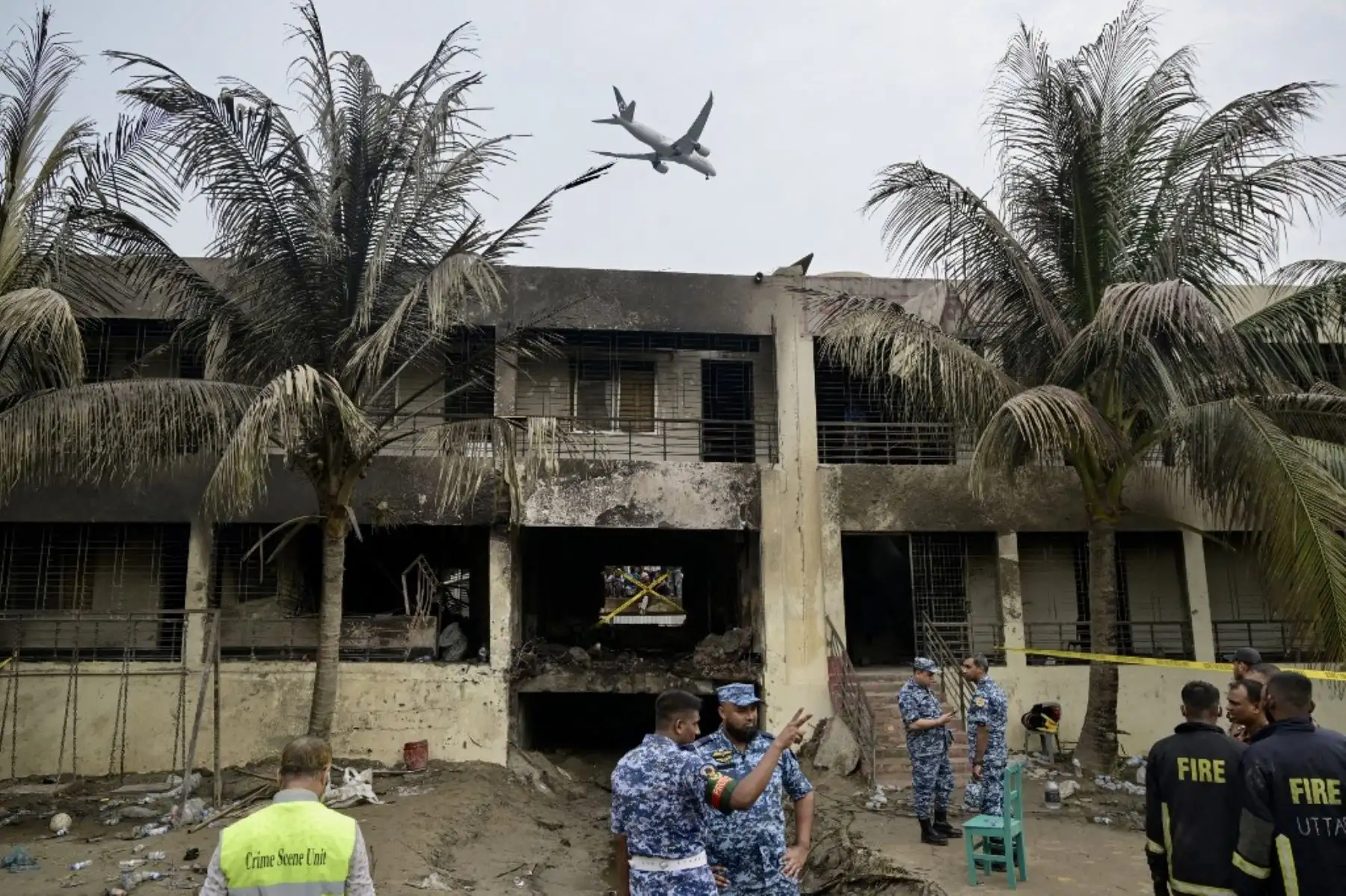 El personal de la Fuerza Aérea de Bangladesh inspecciona el lugar del accidente un día después de que un avión de entrenamiento se estrellara contra una escuela en Dacca el 22 de julio de 2025. Un avión de combate bangladesí se estrelló contra una escuela en la capital, Dacca. AFP