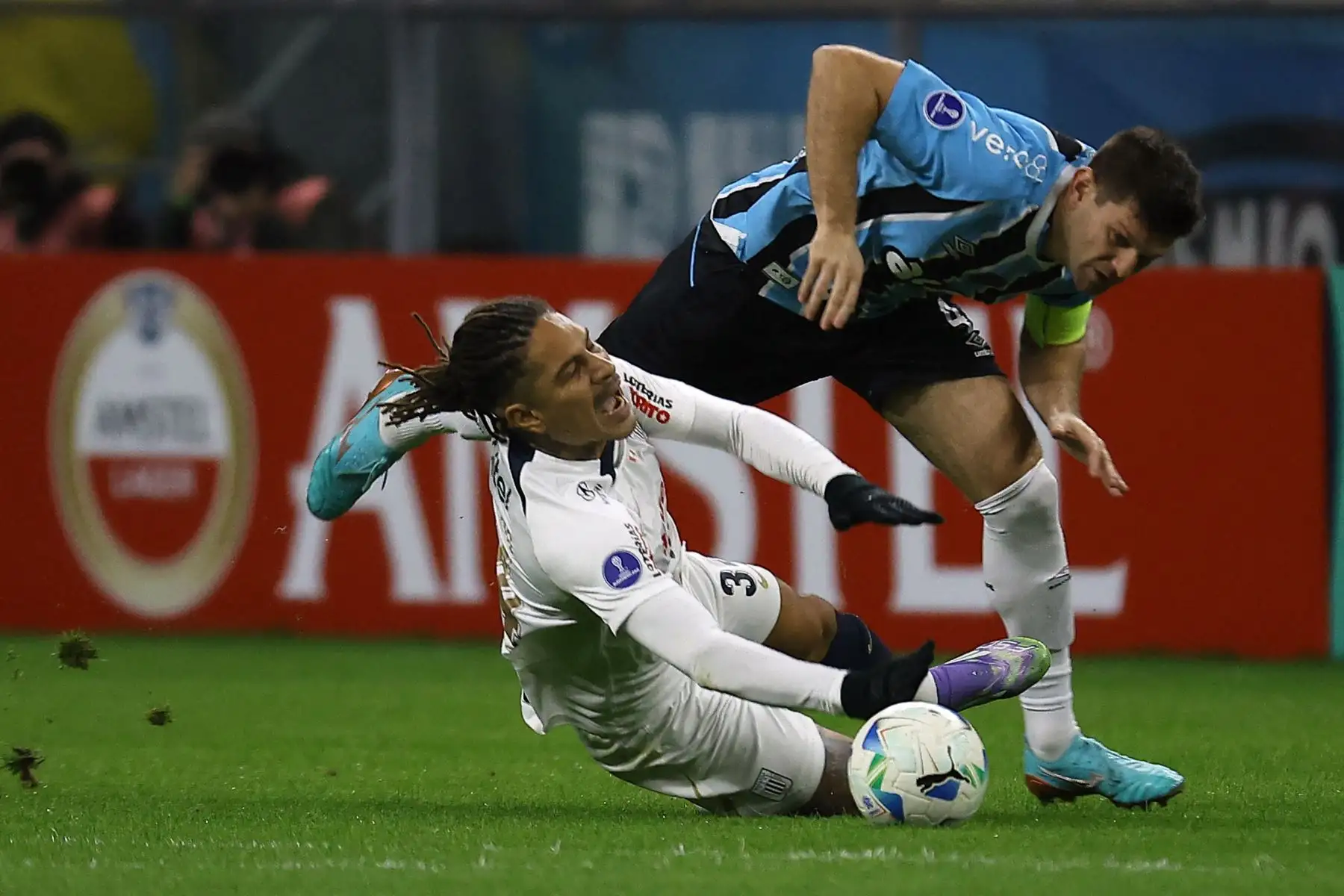 El delantero de Alianza Lima, Paolo Guerrero, y el defensa argentino de Gremio, Walter Kannemann, disputan el balón durante el partido de eliminatoria de la Copa Sudamericana entre Gremio de Brasil y Alianza Lima de Perú en el estadio Arena do Gremio en Porto Alegre. Foto: ANDINA/AFP