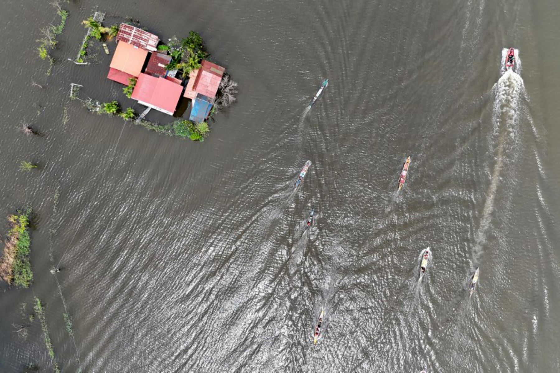 Una vista aérea muestra botes de madera pasando a toda velocidad junto a casas sumergidas en una aldea de Calumpit, provincia de Bulacan, al norte de Manila. Foto: AFP