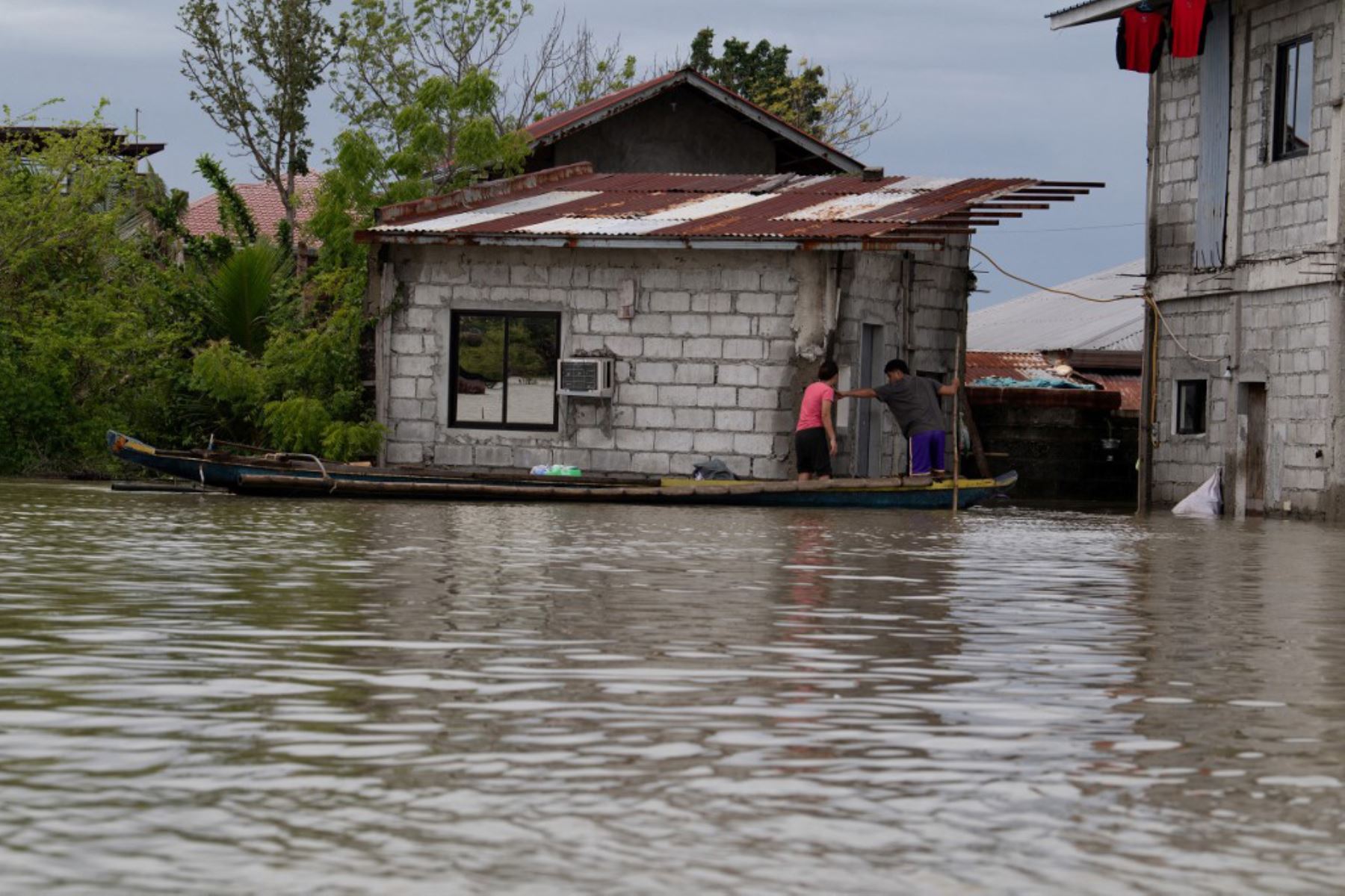 Residentes navegan en barcas de madera en una aldea de Calumpit, provincia de Bulacan, al norte de Manila, tras el desbordamiento de un río debido a las fuertes lluvias provocadas por el tifón Co-May. Foto: AFP