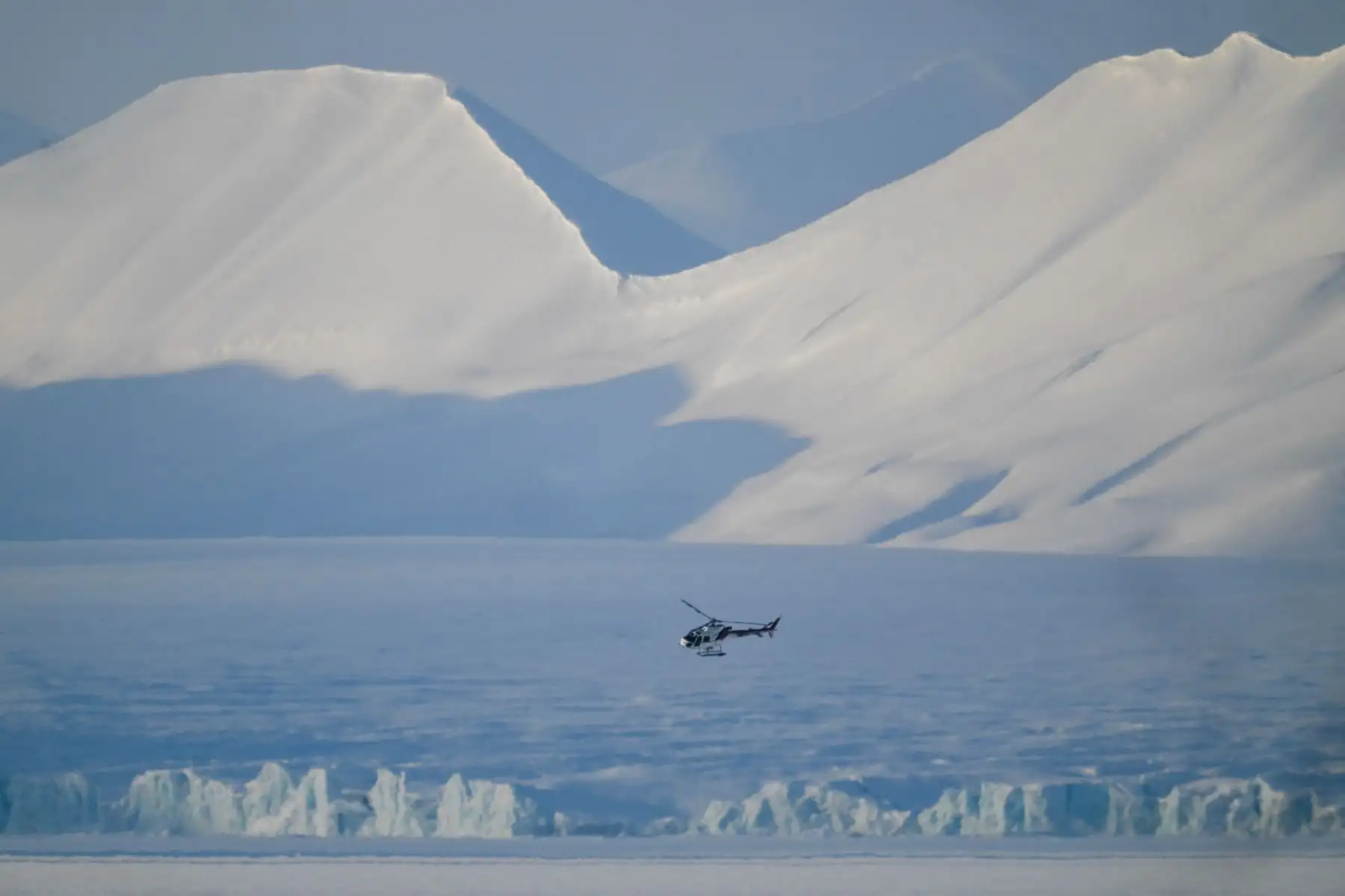 Esta fotografía muestra un helicóptero buscando rastros de osos polares cerca de los glaciares en el este de Spitzbergen, en el archipiélago de Svalbard. AFP