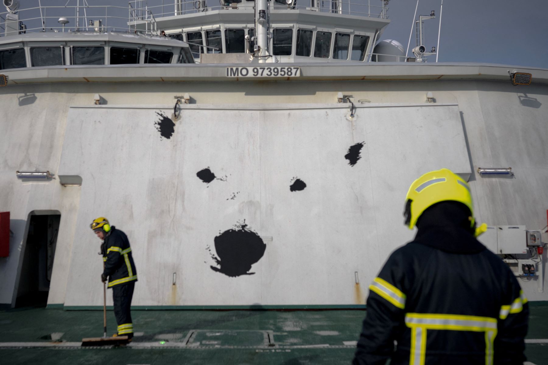 Esta fotografía muestra la puerta del hangar del helicóptero con una cara de oso polar pintada, mientras los técnicos de seguridad trabajan en el puente en el este de Spitzbergen, en el archipiélago de Svalbard. AFP