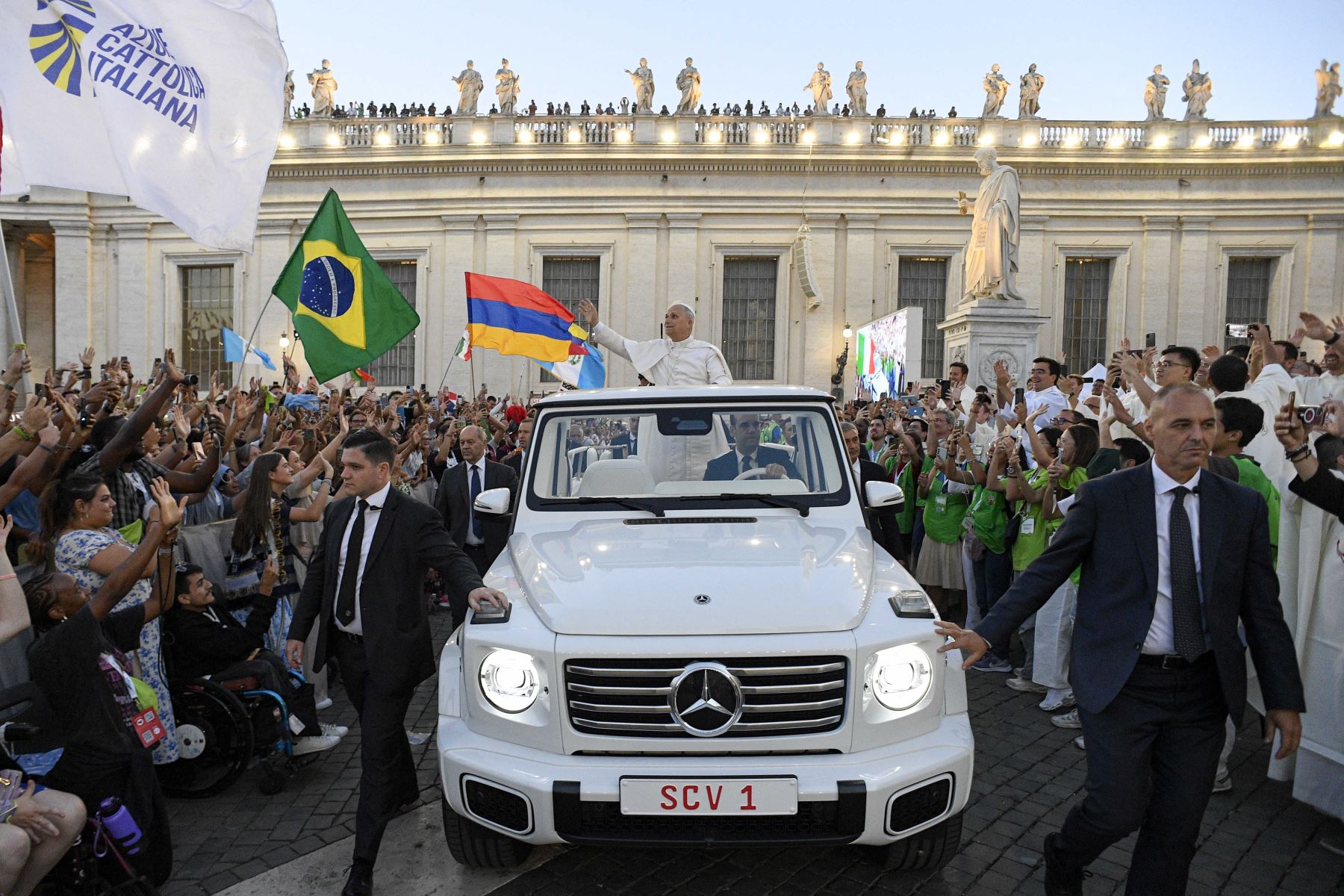 Esta foto difundida por la oficina de prensa del Vaticano, Vatican Media, muestra al Papa León XIV saludando al llegar inesperadamente en el Papamóvil para saludar a los peregrinos que esperaban en la Plaza de San Pedro, antes de la misa inaugural del Jubileo de la Juventud en el Vaticano. Decenas de miles de jóvenes católicos de todo el mundo se reunieron en Roma para una semana de peregrinación durante el Jubileo de la Juventud del Vaticano, un evento que se celebra cada 25 años. AFP