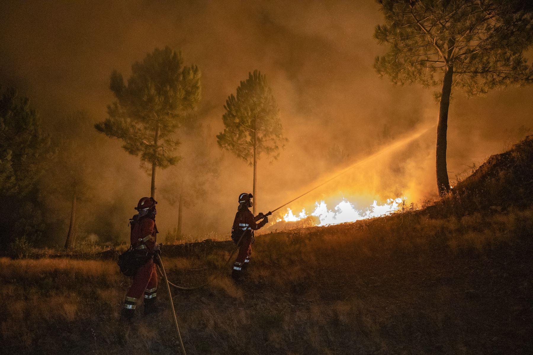 Esta foto, publicada por la Unidad Militar de Emergencias (UME)  muestra a los bomberos combatiendo un incendio forestal cerca de Caminomorisco, en la región de Extremadura, al oeste de España.  Foto: AFP