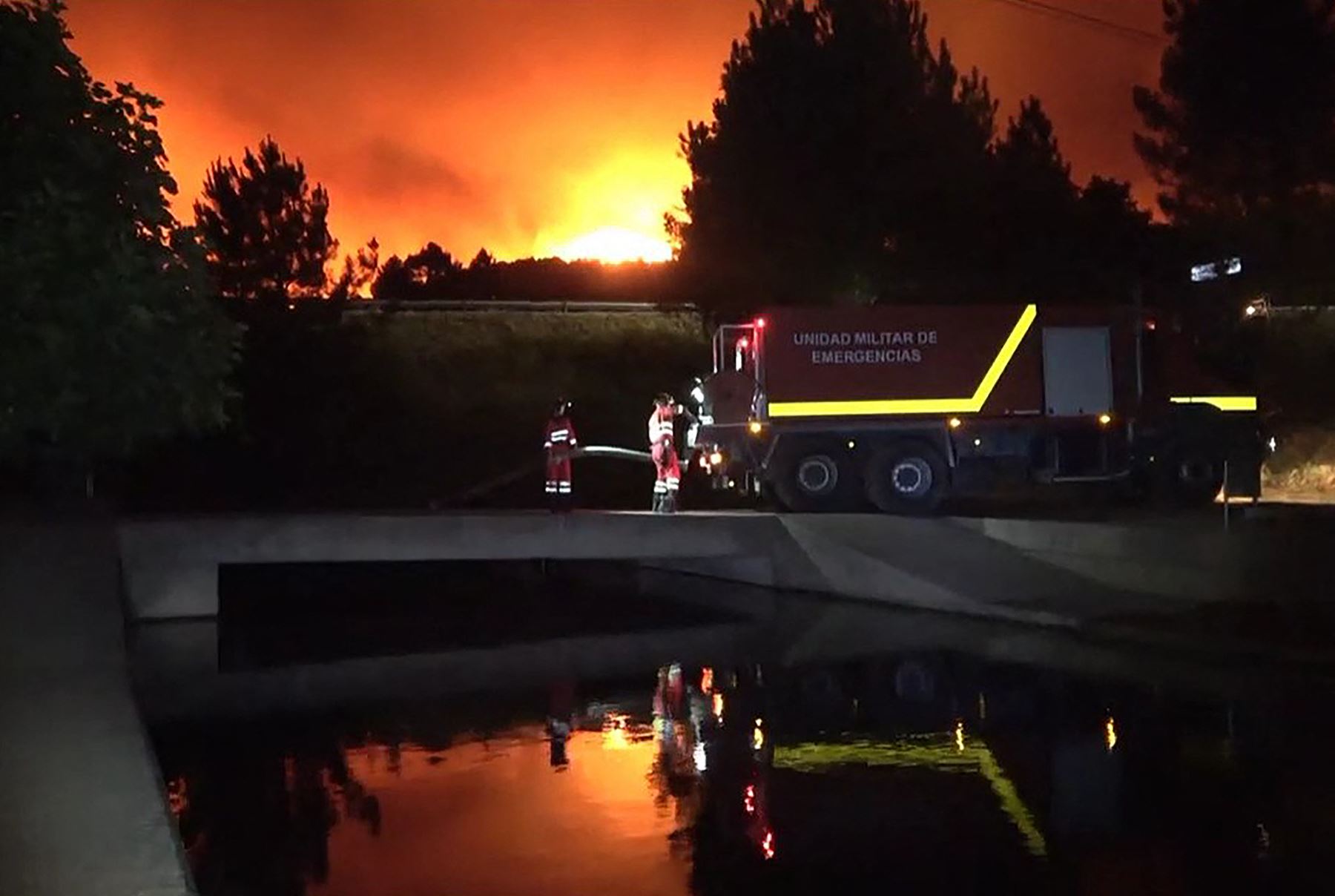 Bomberos recolectan agua para combatir un incendio forestal cerca de Caminomorisco, en Extremadura, noroeste de España.  AFP