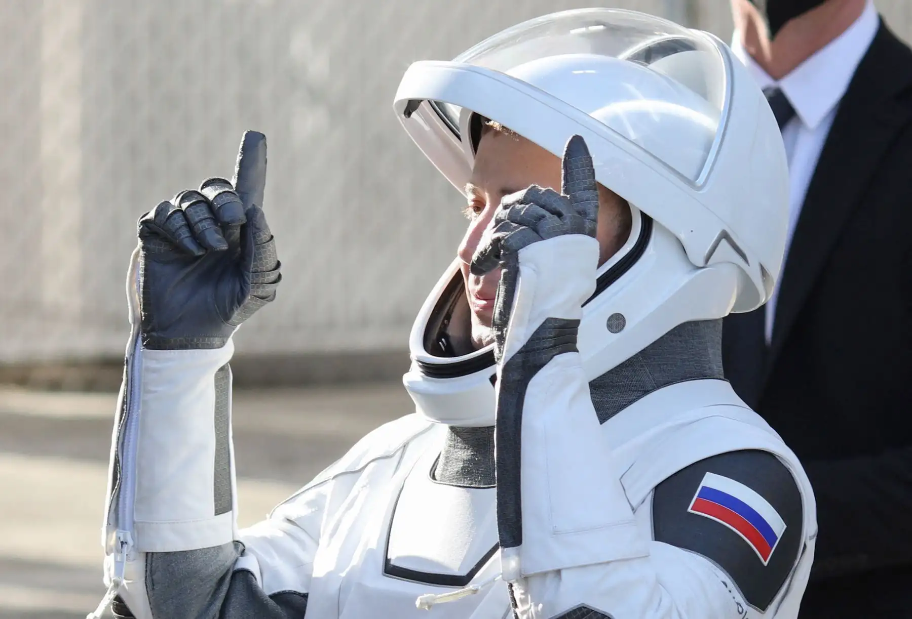 El especialista de misión de Roscosmos, Oleg Platonov, saluda  al salir del edificio de operaciones y control Neil A. Armstrong en ruta al lanzamiento del complejo LC-39A en el Centro Espacial Kennedy en Cabo Cañaveral, Florida. AFP