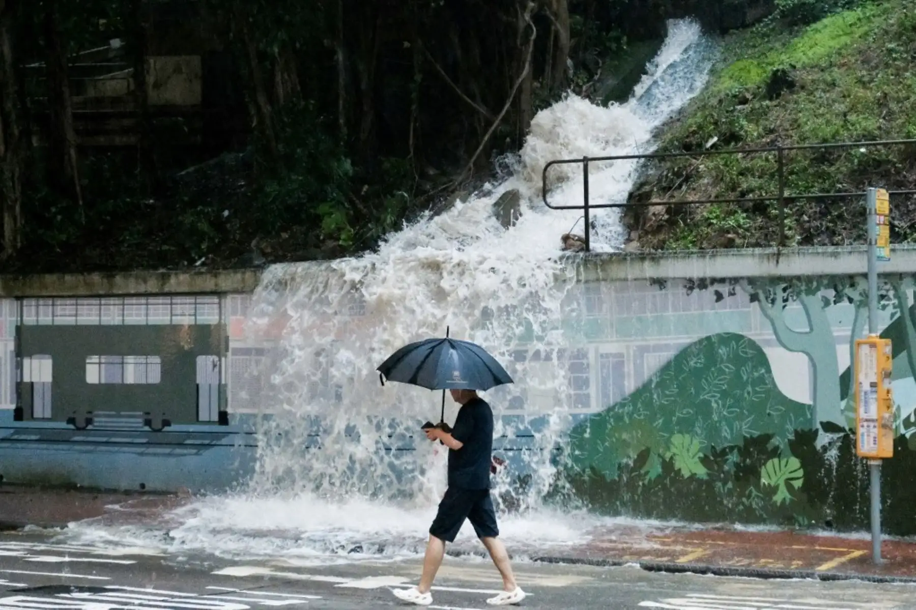 Un peatón pasa junto a un desagüe desbordado en una ladera, derramando agua sobre una calle en la zona de Quarry Bay, Hong Kong, en medio de una alerta de tormenta negra emitida por el observatorio meteorológico de la ciudad. Partes de Hong Kong quedaron paralizadas por las inundaciones causadas por las fuertes lluvias.
Foto: AFP