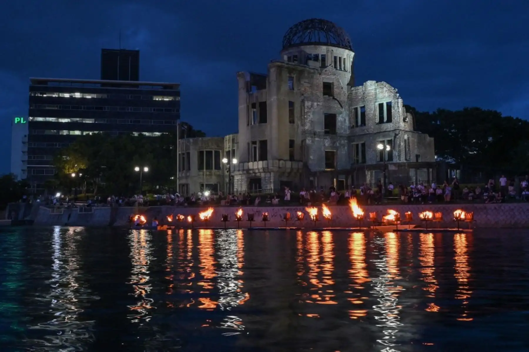 Pequeñas hogueras se encienden a lo largo del río Motoyasu, frente a la Cúpula de la Bomba Atómica, durante una ceremonia en memoria de las víctimas en vísperas del 80 aniversario del primer ataque con bomba atómica del mundo, en la ciudad de Hiroshima. Foto: AFP