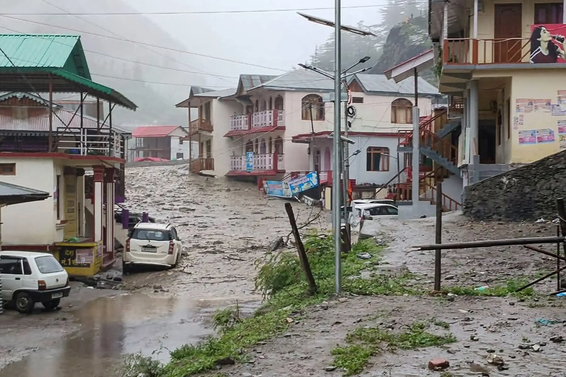 Agua turbia fluyendo junto a edificios residenciales después de que un aguacero causara un deslizamiento de tierra masivo en el estado indio de Uttarakhand.  AFP