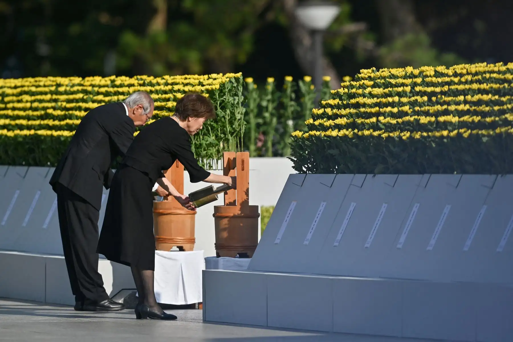 Una pareja de ancianos hace una ofrenda de agua al inicio de la ceremonia para representar la primera agua ofrecida a las víctimas después del bombardeo, durante la Ceremonia Conmemorativa de la Paz para conmemorar el 80 aniversario del primer ataque con bomba atómica del mundo, en la ciudad de Hiroshima AFP