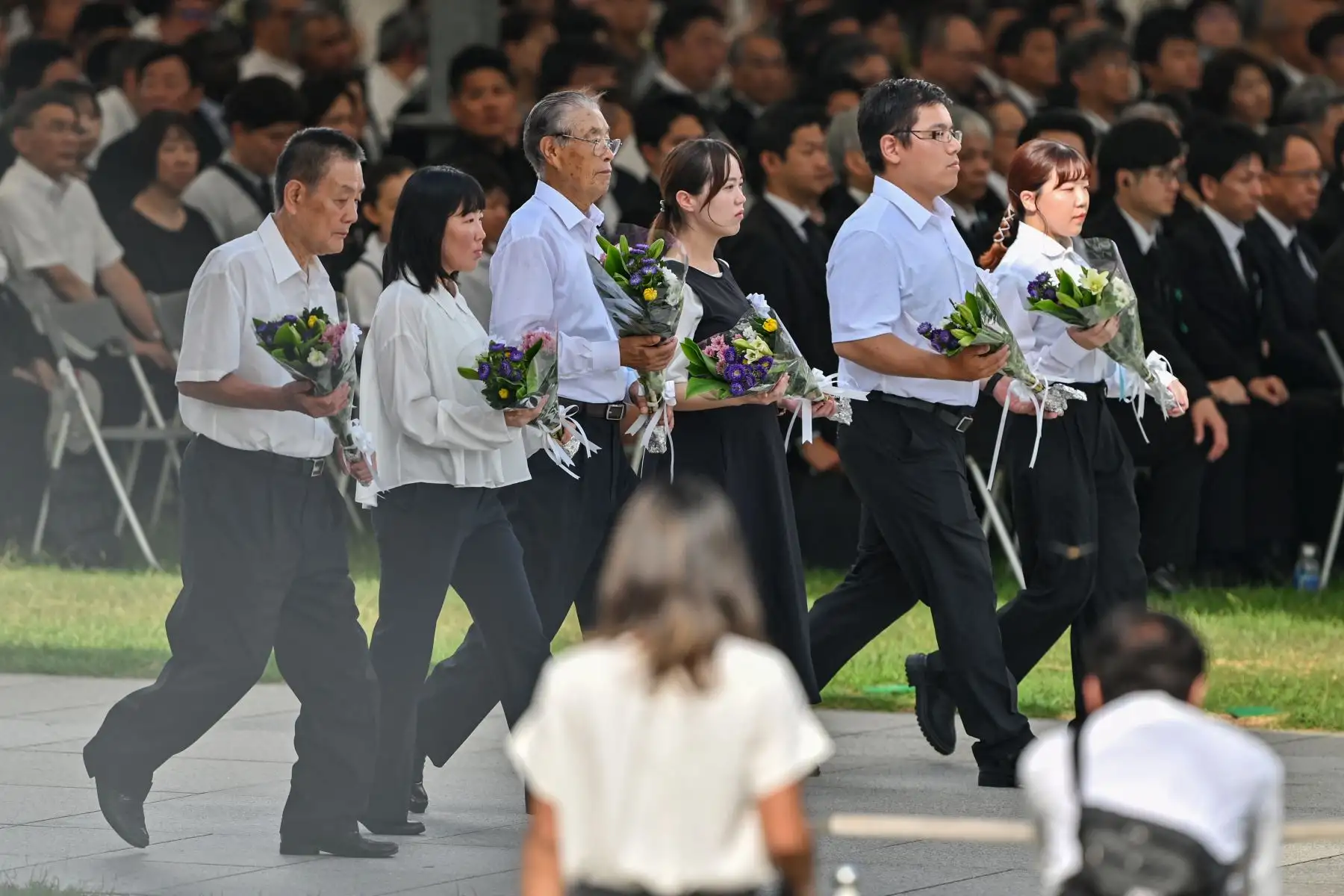 Los invitados llevan ramos de flores para depositarlos en el Cenotafio Memorial durante la Ceremonia Conmemorativa de la Paz para conmemorar el 80 aniversario del primer ataque con bomba atómica del mundo, en la ciudad de Hiroshima. AFP