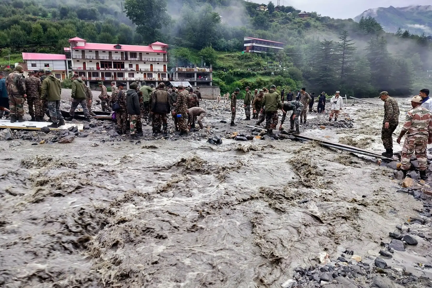 En esta fotografía, publicada  por el Ejército de la India, se muestra al personal de seguridad y socorro levantando piedras y retirando escombros para construir un cruce sobre un arroyo de lodo denso durante una operación de búsqueda y rescate, un día después de que un aguacero causara un deslizamiento de tierra masivo e inundaciones repentinas en el estado indio de Uttarakhand. 
Foto: AFP