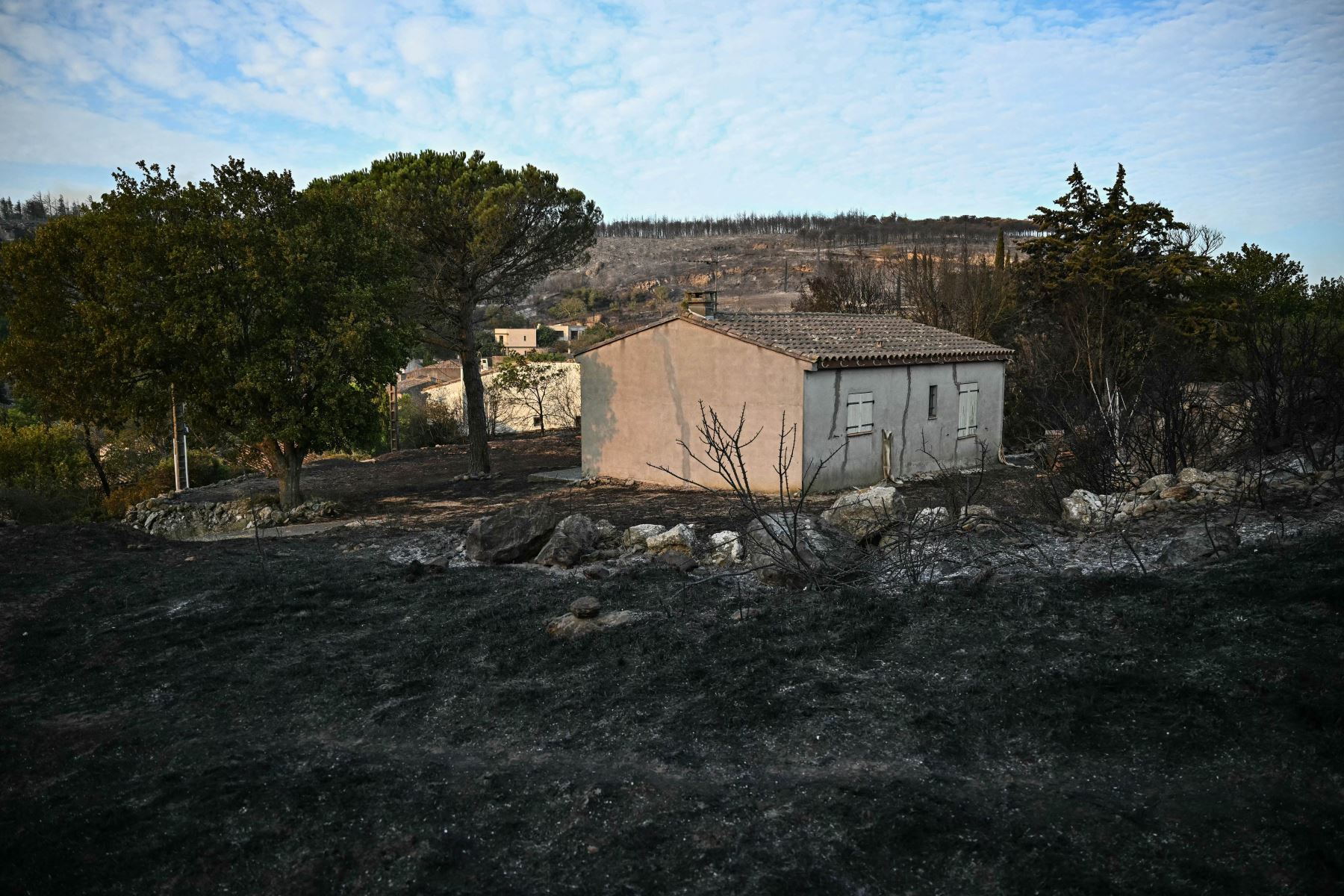 Esta fotografía muestra una casa en una zona devastada por un incendio forestal cerca de Fontjoncouse, en el suroeste de Francia. Un incendio forestal ha causado la muerte de una persona y herido a otras nueve, arrasando 11.000 hectáreas mientras los bomberos trabajan para contenerlo, según informaron las autoridades locales.
Foto: AFP