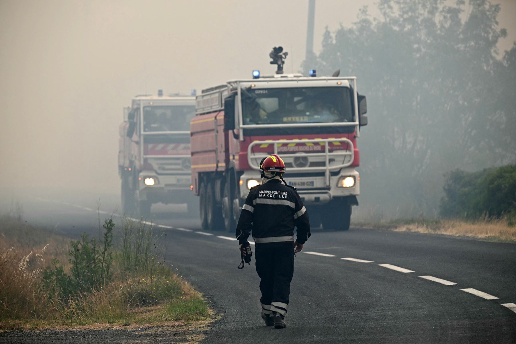 Vehículos de bomberos se dirigen hacia un incendio forestal cerca de Fontjoncouse, en el suroeste de Francia. Un incendio forestal ha causado la muerte de una persona y herido a otras nueve, arrasando 11.000 hectáreas mientras los bomberos trabajan para contenerlo, según informaron las autoridades locales. 
Foto: AFP