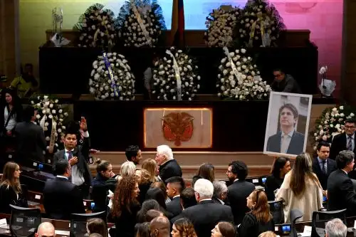 Familiares del fallecido candidato presidencial colombiano Miguel Uribe y miembros del Congreso asisten a su velatorio en el Congreso en Bogotá. AFP