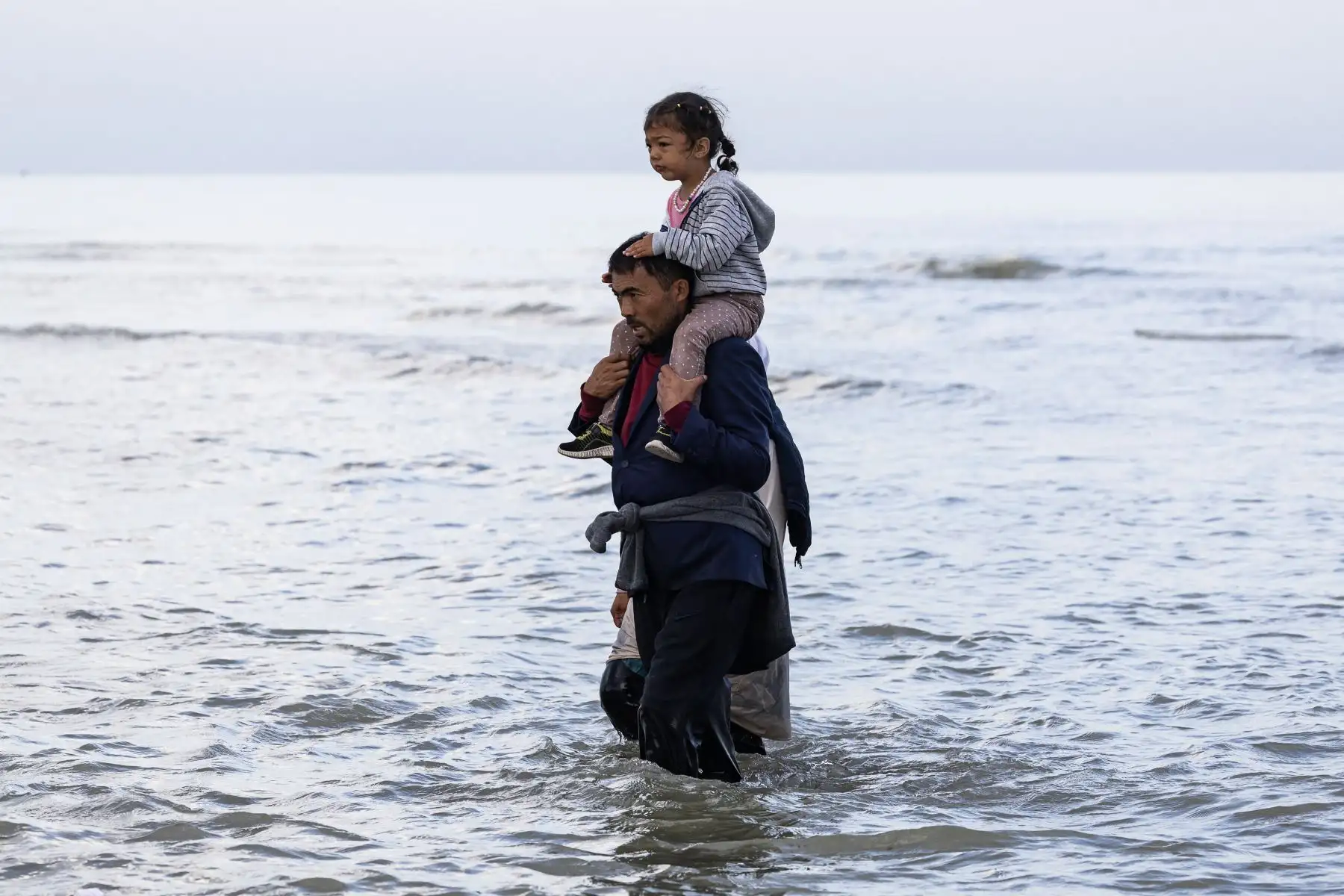Una migrante reacciona al no poder abordar el barco de un contrabandista en un intento de cruzar el Canal de la Mancha frente a la playa de Gravelines, en el norte de Francia. AFP