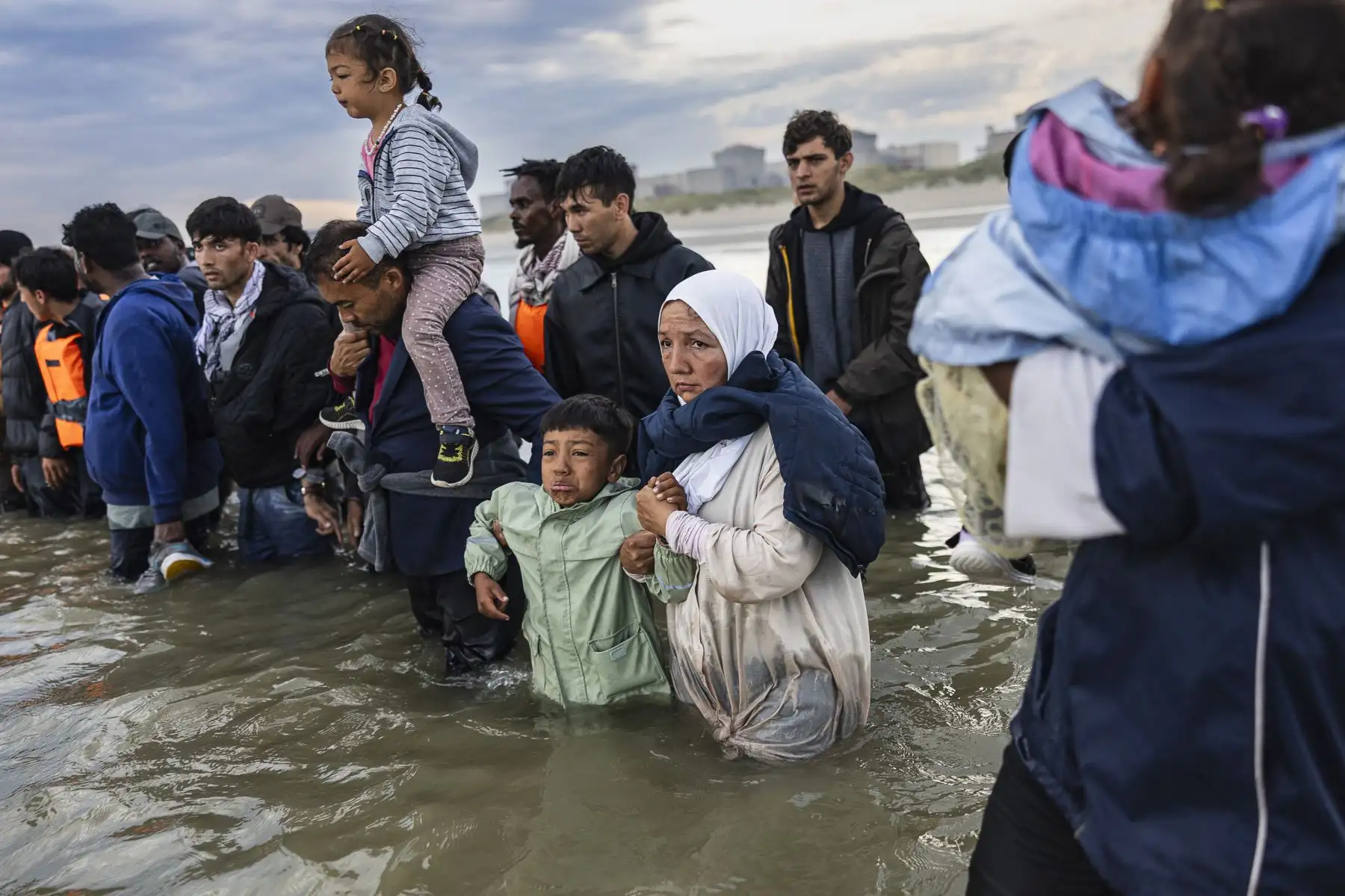 Un niño llora mientras los migrantes intentan abordar el barco de un contrabandista en un intento de cruzar el Canal de la Mancha frente a la playa de Gravelines, en el norte de Francia. AFP