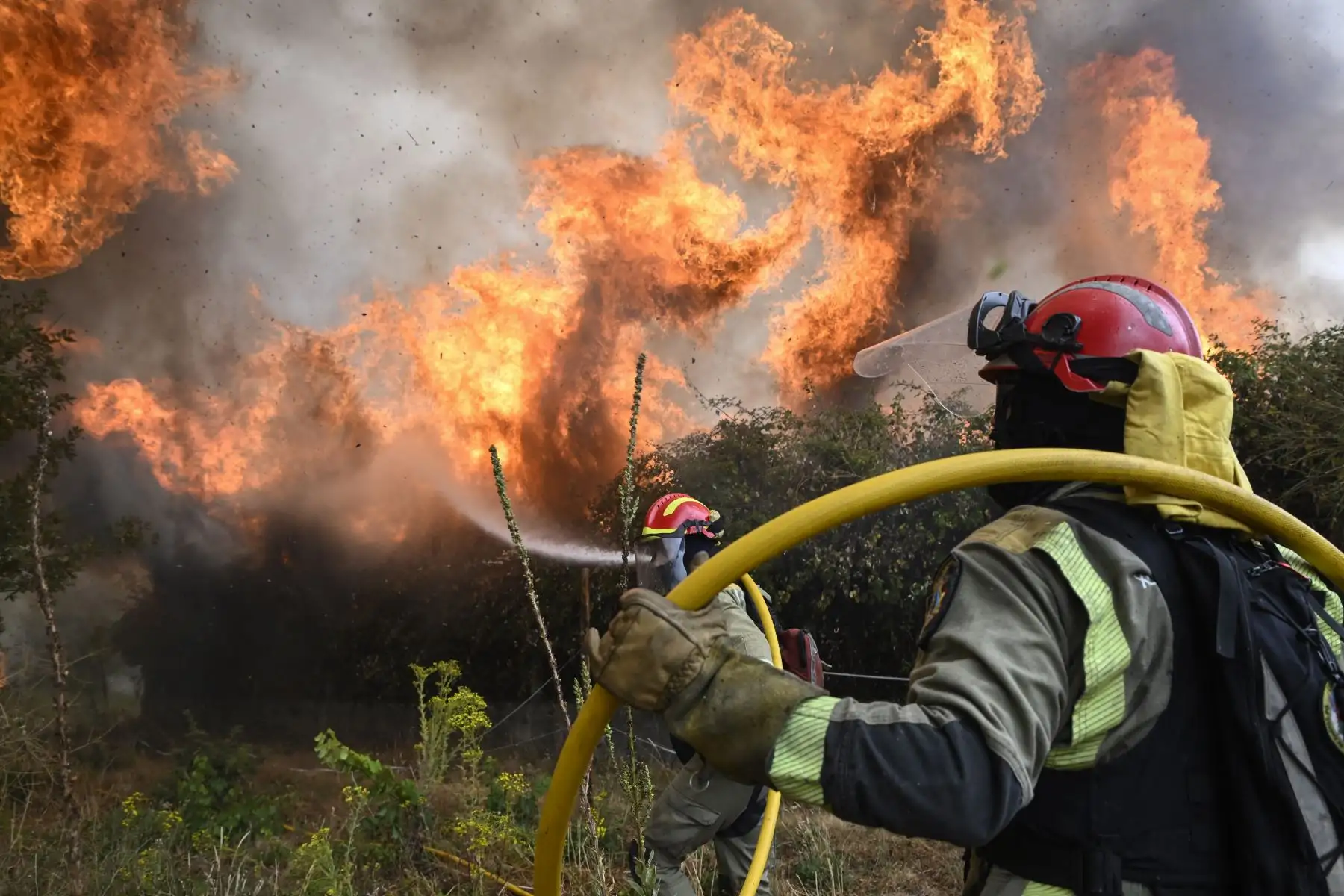 Un bombero cae al suelo mientras trabaja para extinguir un incendio forestal en San Cibrao das Vias, en las afueras de Ourense, en el noroeste de España. AFP