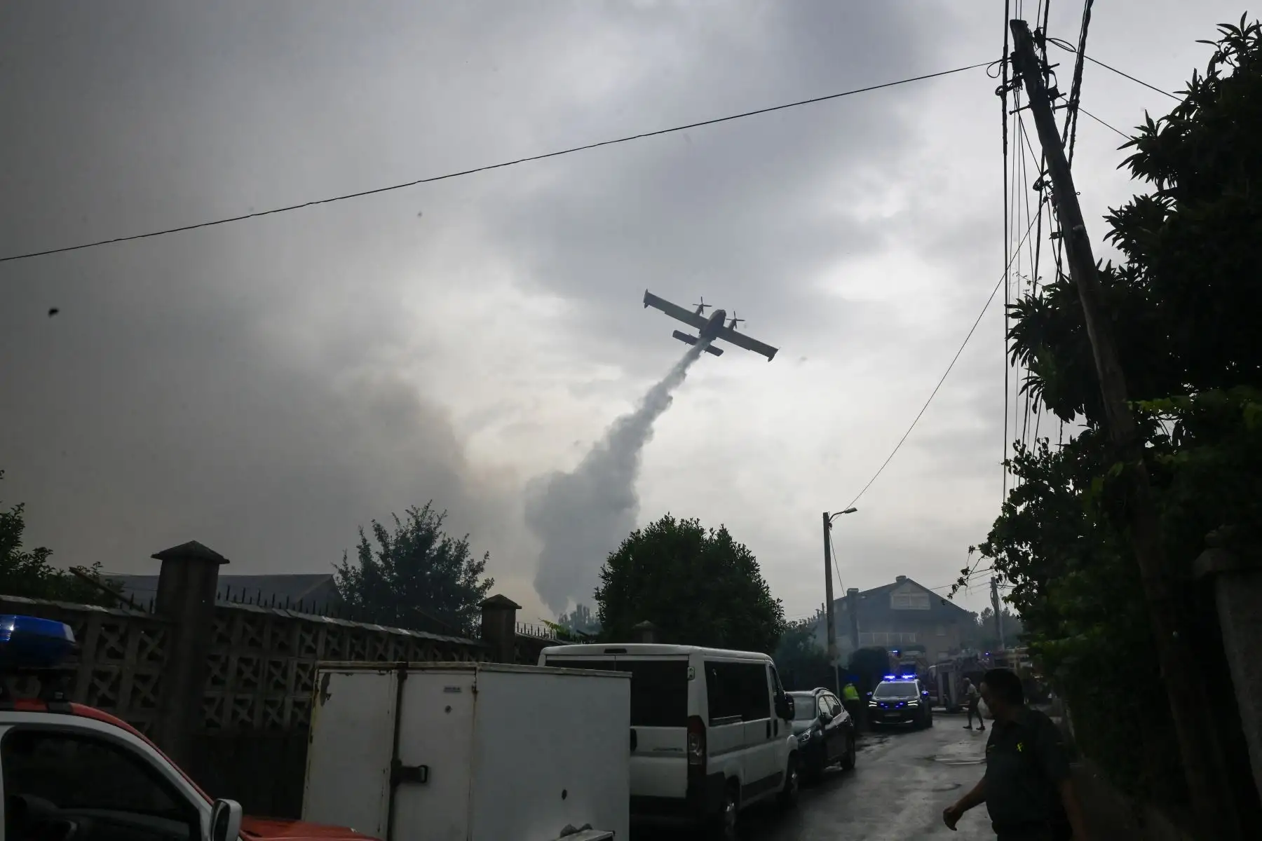 Un avión de extinción de incendios arroja agua sobre un incendio forestal en San Cibrao das ViÒas, a las afueras de Ourense, en el noroeste de España. AFP