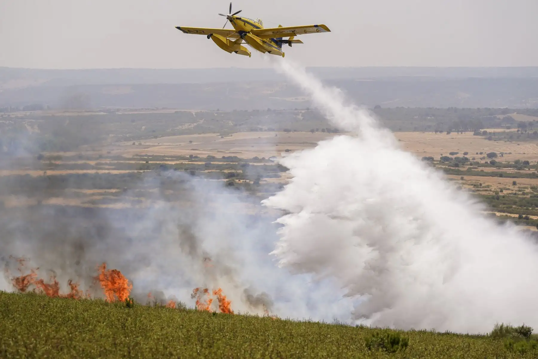 Un avión de bomberos vierte agua sobre un incendio forestal en Puercas de Aliste, cerca de Zamora. AFP