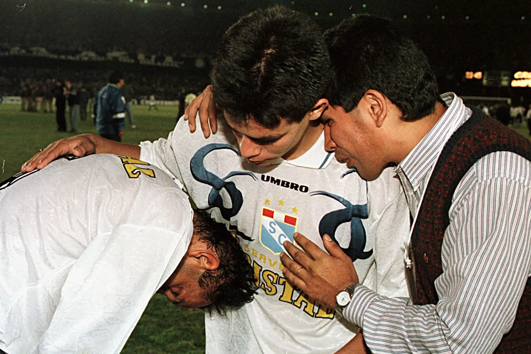 Garay, capitán del equipo Sporting Cristal de Perú, es consolado por su compañero Soto y un dirigente, al fin del partido final de la Copa Libertadores de América 13 de Agosto en Belo Horizonte, Brasil. Cruzeiro sagrose campeon de dicho torneo con la vitoria de 1-0 sobre el Sporting Cristal. AFP