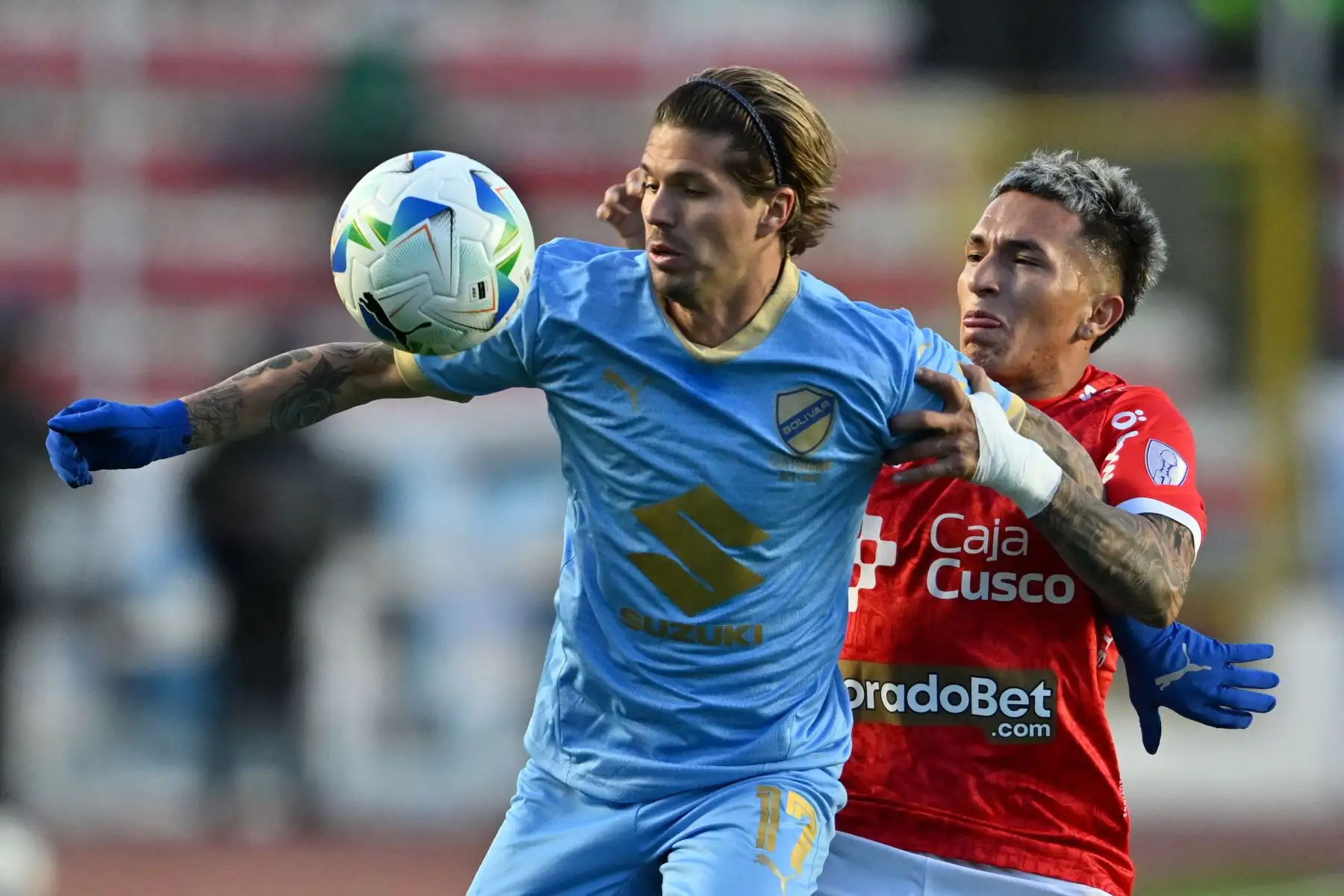 El delantero argentino  de Bolívar, Patricio Rodríguez , y el mediocampista  de Cienciano, Cristian Neira, luchan por el balón durante el partido de ida de los octavos de final de la Copa Sudamericana entre Bolívar de Bolivia y Cienciano de Perú. AFP