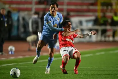 El defensa de Bolívar José Sagredo y el mediocampista de Cienciano Cristian Neira luchan por el balón. Foto: AFP.