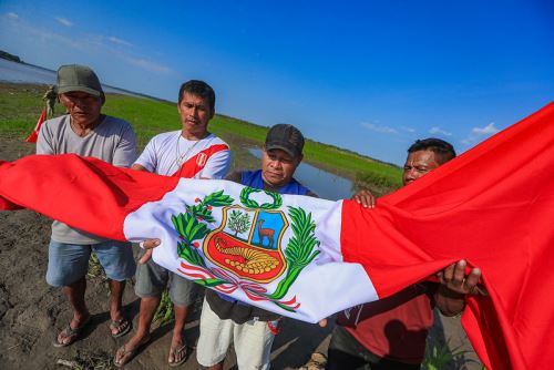Ciudadanos de Santa Rosa de Loreto y los miembros de las Fuerzas Armadas izan el pabellón y cantando el himno nacional en la isla Chinería