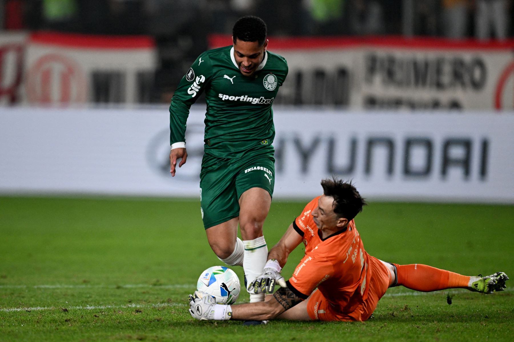 El delantero de Palmeiras  Vitor Roque y el portero uruguayo de Universitario Sebastián Britos luchan por el balón durante el partido de ida de los octavos de final de la Copa Libertadores entre Universitario de Perú y Palmeiras de Brasil. AFP