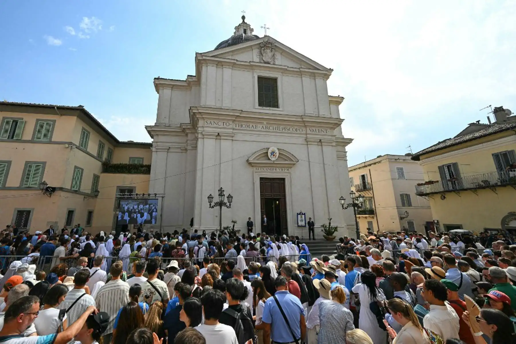 Los fieles observan la misa de la Asunción oficiada por el Papa en una pantalla en el exterior de la Parroquia Pontificia de Santo Tomás de Villanova, en la residencia papal de verano de Castel Gandolfo, al sureste de Roma. Foto: AFP