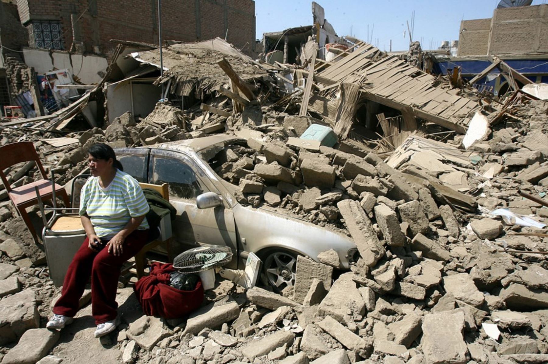 Una mujer guarda sus pertenencias junto a un auto sumergido entre las ruinas derruidas por un terremoto el día anterior, el 16 de agosto de 2007, en Ica, al sur de Lima. Foto:Ñ ANDINA/ Carlos Américo Lezama Villantoy