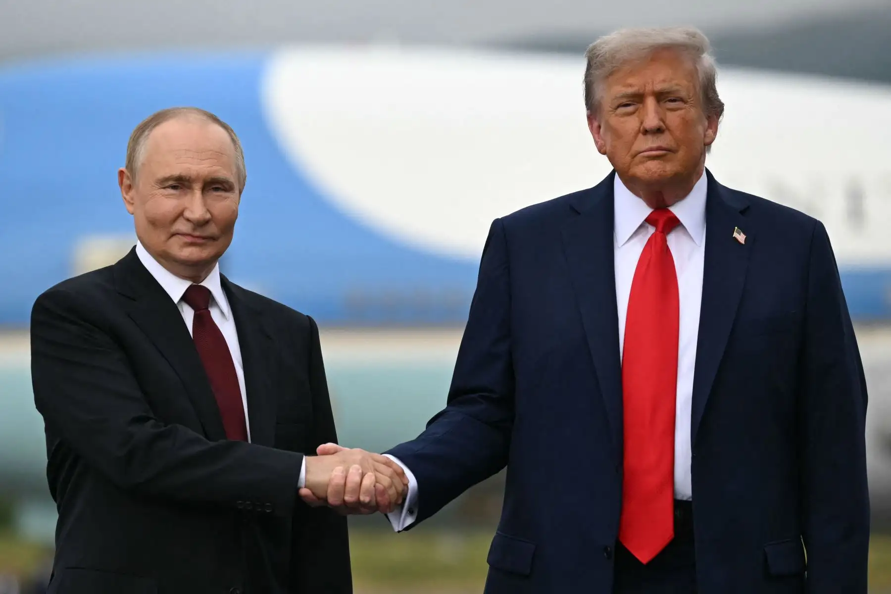 El presidente de Estados Unidos, Donald Trump , y el presidente ruso, Vladimir Putin, se estrechan la mano mientras posan en un podio en la pista después de llegar a la Base Conjunta Elmendorf-Richardson en Anchorage, Alaska. AFP