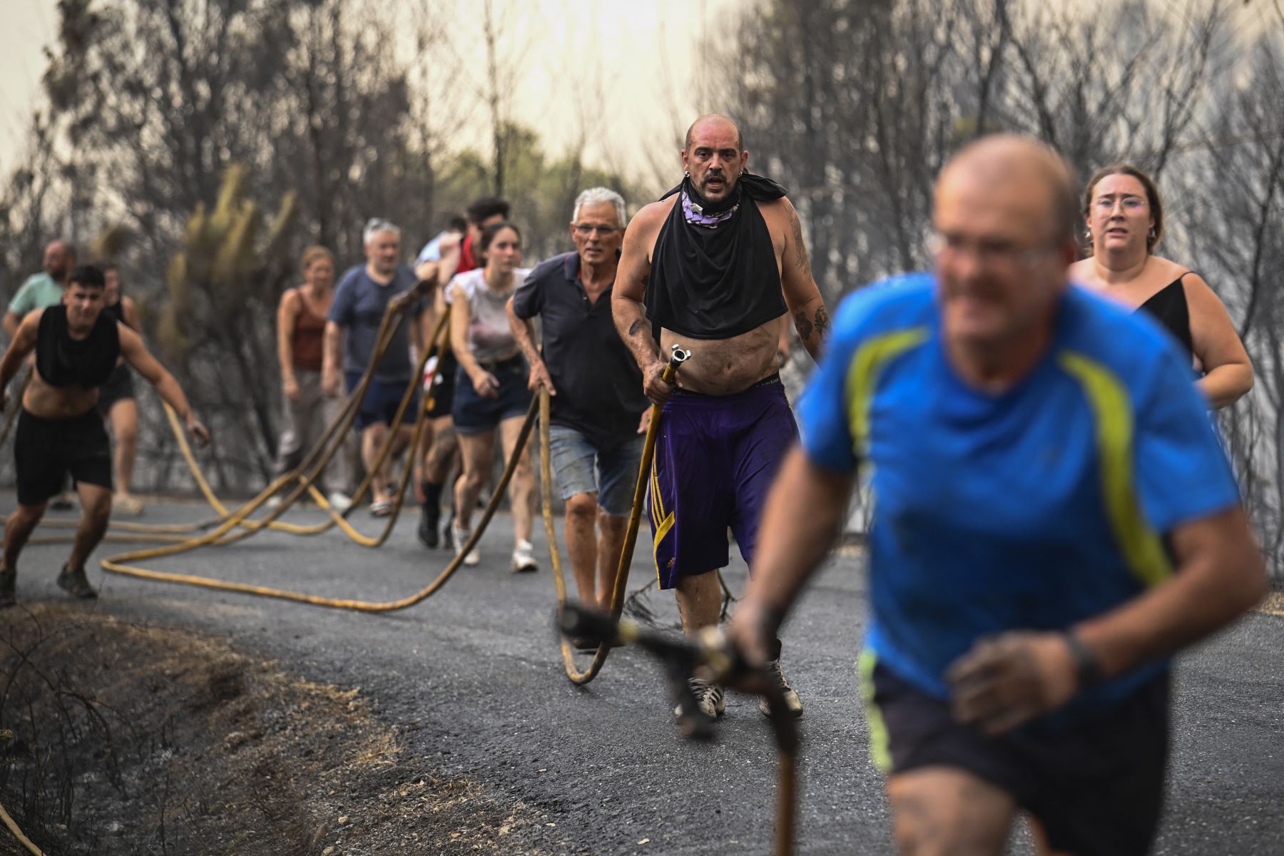 La gente intenta extinguir un incendio forestal cerca del pueblo de Larouco, en la provincia de Ourense, en el noroeste de España. AFP