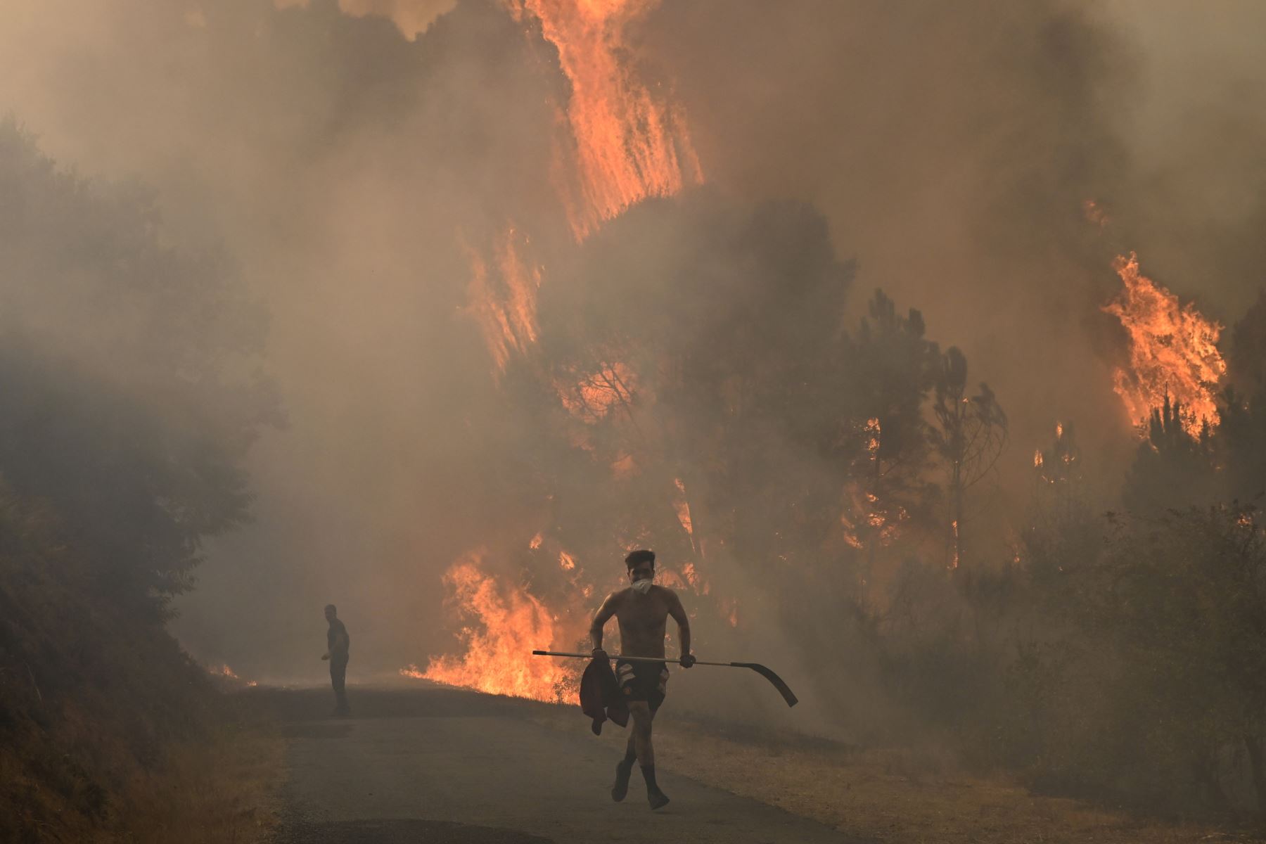 Un hombre huye de las llamas durante un incendio forestal cerca del pueblo de Larouco, en la provincia de Ourense, en el noroeste de España. AFP