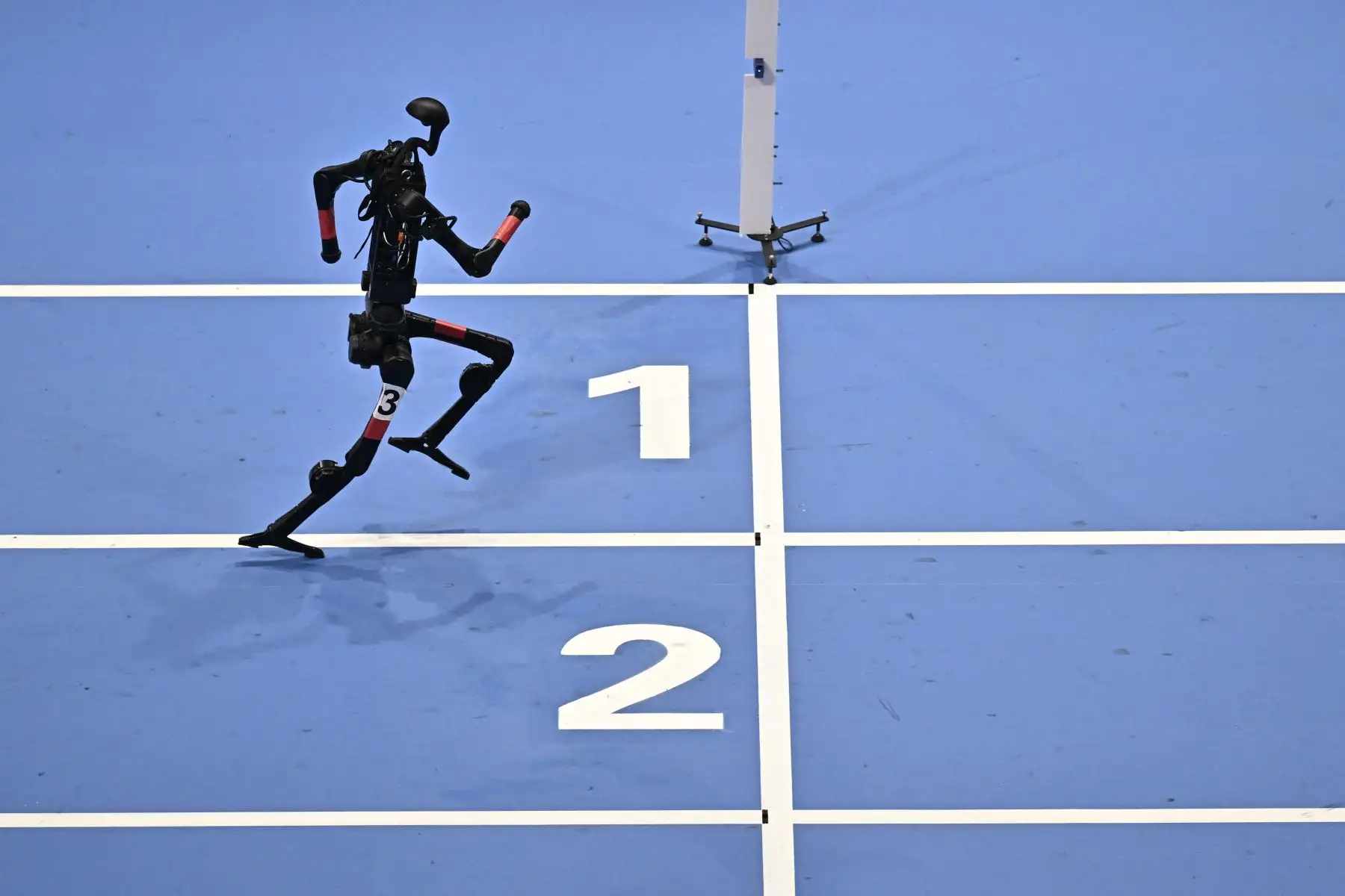 Un robot compite en una final de relevos de 4x100 m durante los Juegos Mundiales de Robots Humanoides en Pekín.
Foto: AFP