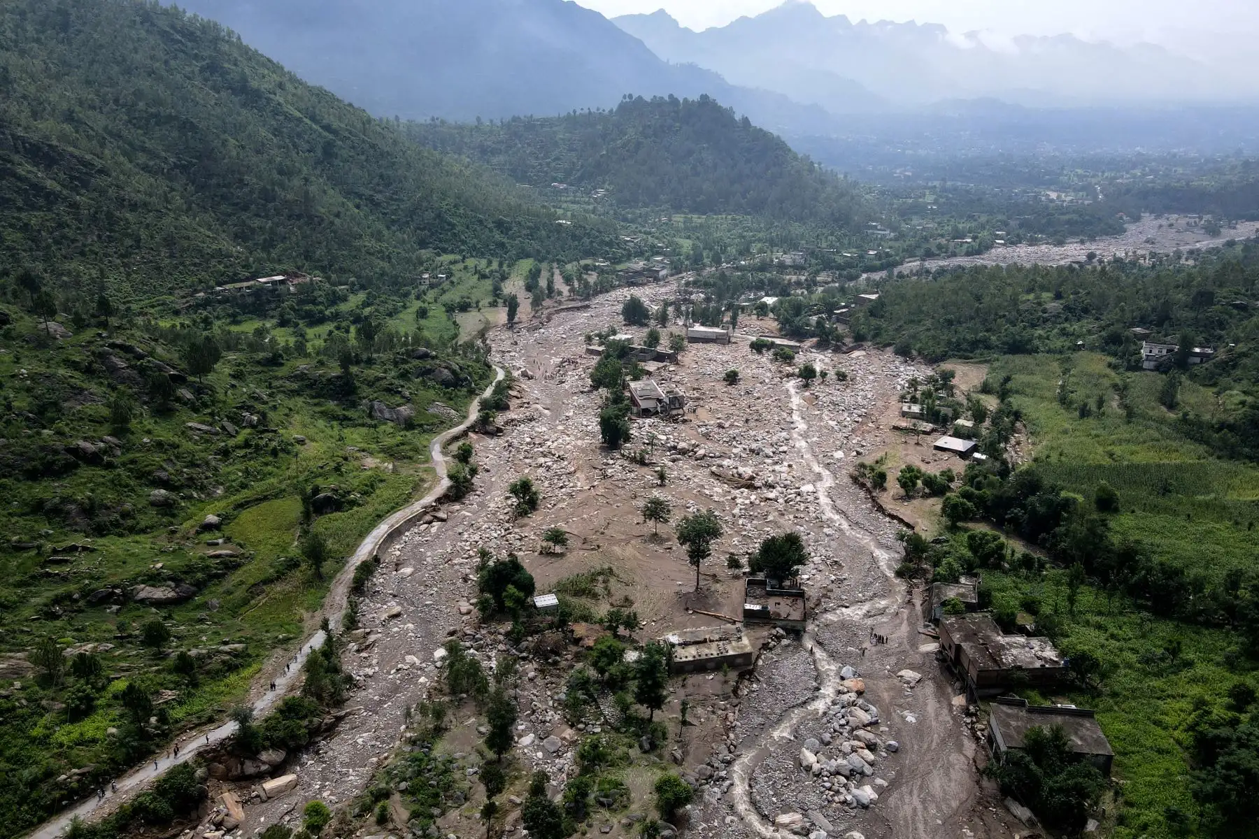 Una vista aérea muestra casas parcialmente sumergidas en lodo a lo largo del lecho de un río después de las inundaciones repentinas en el distrito de Buner, en la montañosa provincia de Khyber Pakhtunkhwa.
Foto: AFP