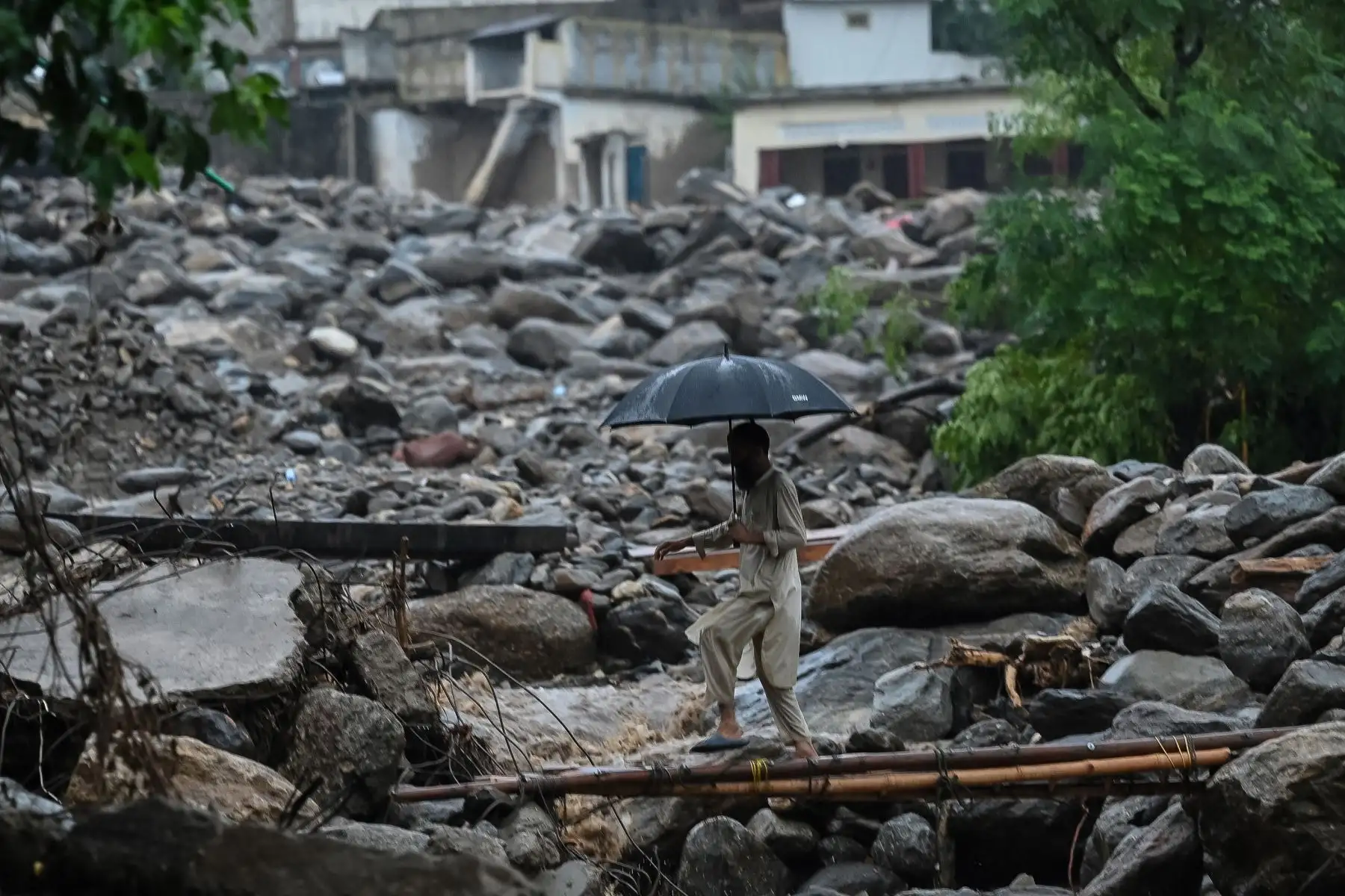 Un aldeano cruza un puente temporal en el lugar de una inundación repentina en el distrito de Buner, provincia pakistaní de Khyber Pakhtunkhwa.
Foto: AFP