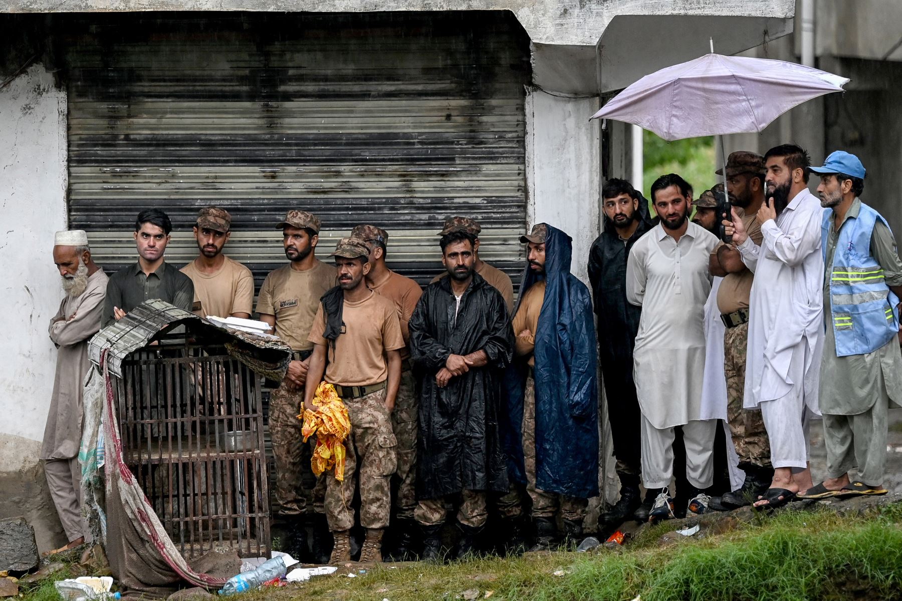 Rescatistas y personal del ejército se refugian bajo el techo de un edificio mientras los niveles de las aguas aumentan en el distrito de Buner de la provincia de Khyber Pakhtunkhwa de Pakistán.
Foto: AFP