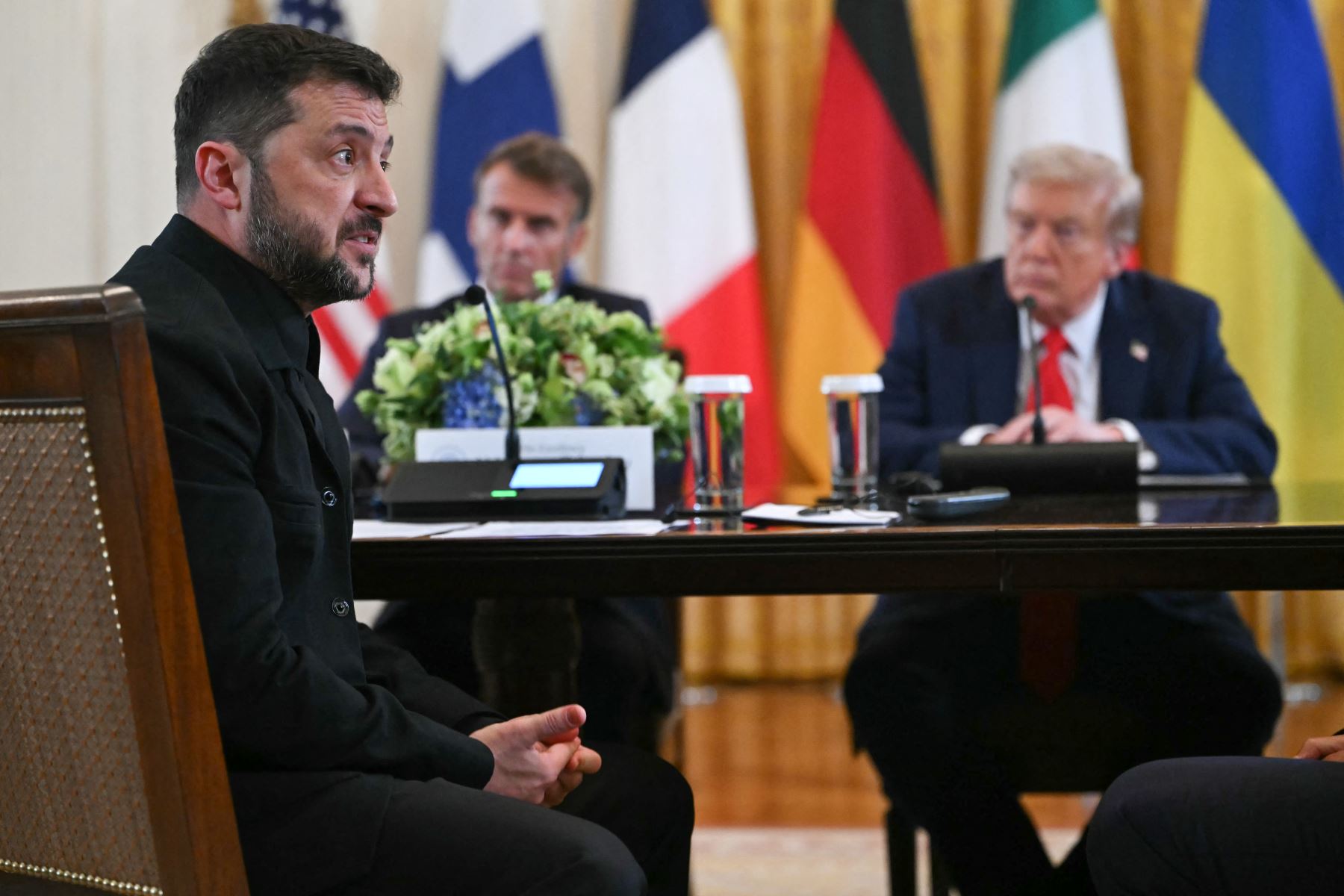 El presidente ucraniano, Volodymyr Zelensky, habla mientras el presidente francés, Emmanuel Macron, y el presidente estadounidense, Donald Trump, escuchan durante una reunión con líderes europeos en la Sala Este de la Casa Blanca en Washington, DC. AFP