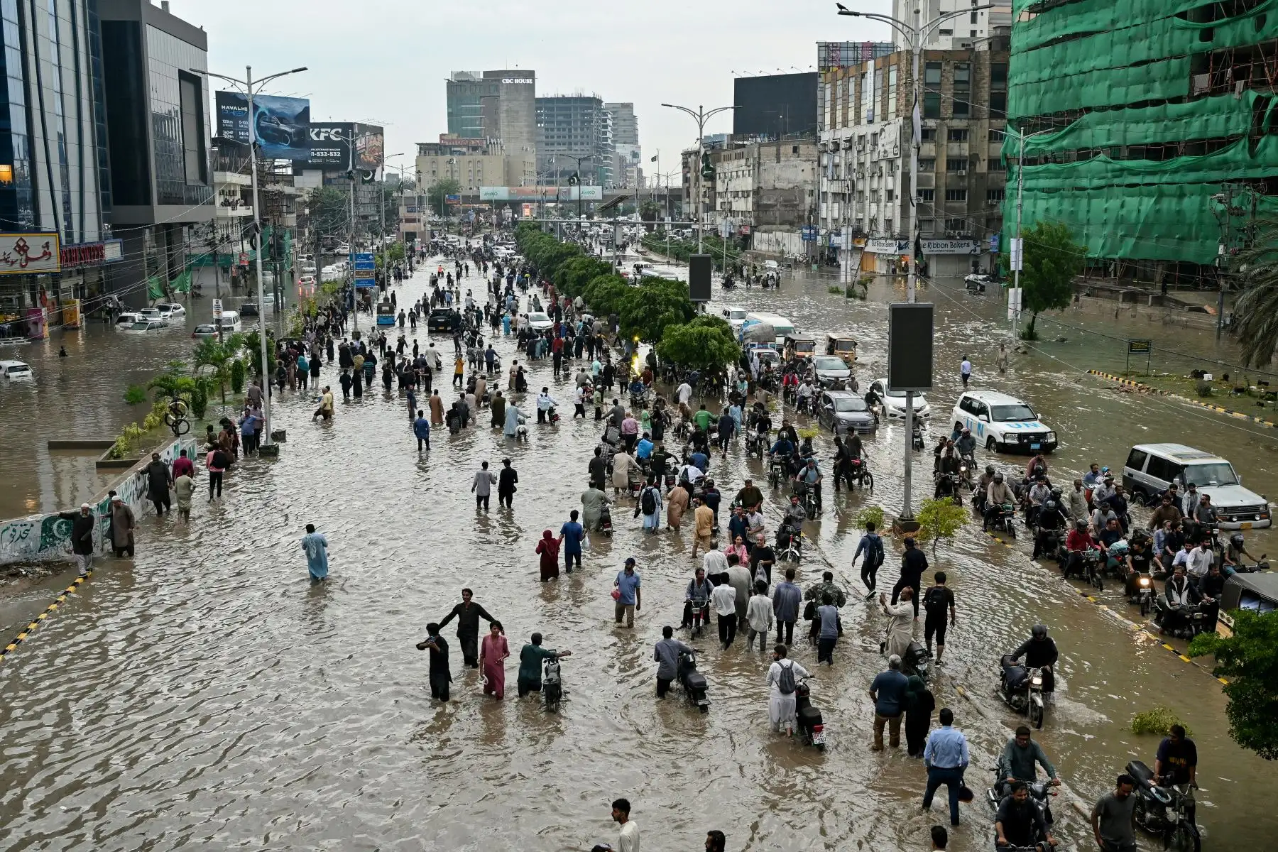 La gente camina por una calle inundada después de fuertes lluvias en Karachi. Foto: AFP