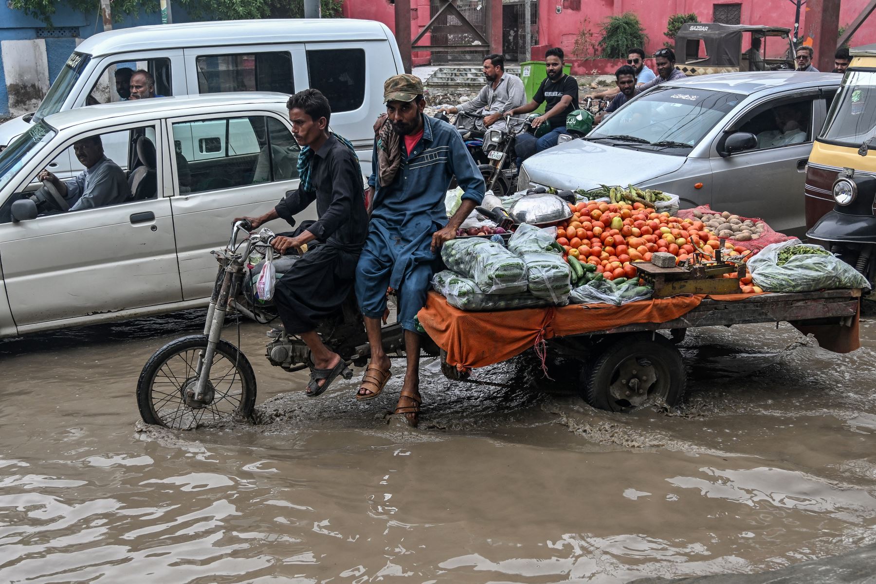 Vendedores de verduras viajan en su carro por una calle inundada después de la lluvia en Karachi . AFP