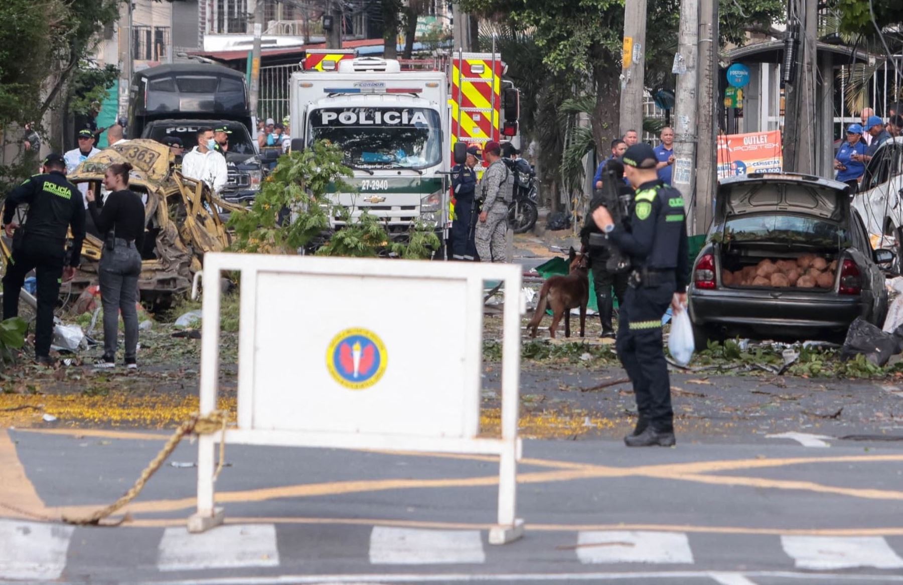 Miembros de la policía colombiana inspeccionan el área de una explosión de bomba en Cali, Colombia. Cinco personas murieron y decenas resultaron heridas cuando un vehículo bomba tuvo como blanco una base militar en una concurrida calle de la ciudad colombiana de Cali. Foto: AFP