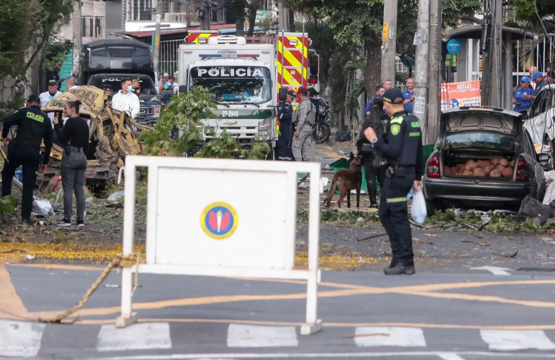 Miembros de la policía colombiana inspeccionan el área de una explosión de bomba en Cali, Colombia. Cinco personas murieron y decenas resultaron heridas cuando un vehículo bomba tuvo como blanco una base militar en una concurrida calle de la ciudad colombiana de Cali. Foto: AFP