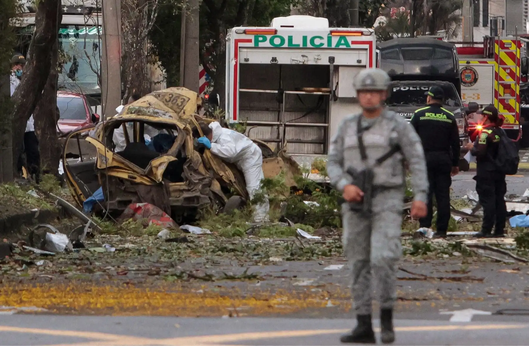 Un oficial de policía inspecciona los restos de un automóvil en el lugar de la explosión de una bomba en Cali, Colombia. AFP
