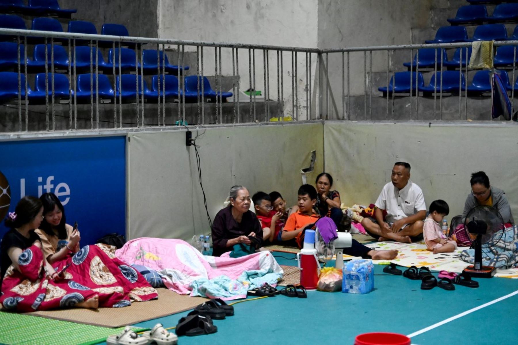 Personas se refugian en el Gimnasio Provincial de Nghe An, en la ciudad de Vinh, provincia de Nghe An, el 25 de agosto de 2025, antes de que el tifón Kajiki tocara tierra en Vietnam, con vientos de unos 160 km/h. Decenas de miles de residentes fueron evacuados de la costa vietnamita. Foto: AFP