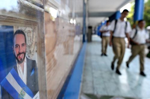 Estudiantes salvadoreños pasan junto a una foto del presidente Bukele en el Instituto Técnico Industrial Nacional. Foto: AFP